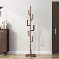 a coat rack in the corner of a room with a door and wooden flooring