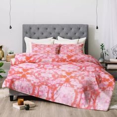 a bed covered in pink and orange tie dye sheets