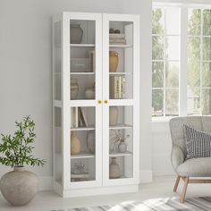 a white bookcase with glass doors in a living room