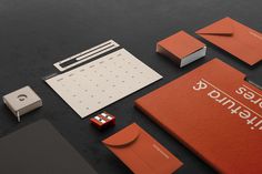 an assortment of stationery items displayed on a black surface with red and white accents