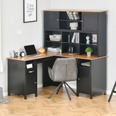 a computer desk with a laptop on it in front of a bookcase and chair