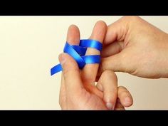 two hands are holding something blue and one has a small object in the other hand