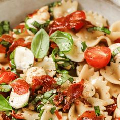 pasta with tomatoes, mozzarella and spinach in a bowl