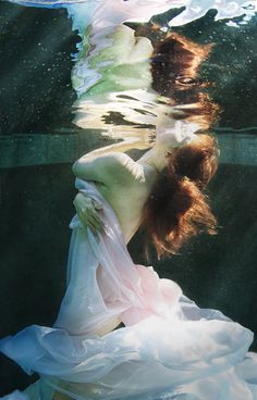 a woman in a white dress under water