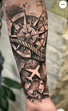 a man's arm with a compass and world map tattoo on the left forearm