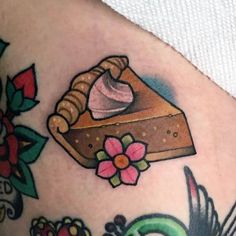 a close up of a piece of food on a woman's thigh with tattoos