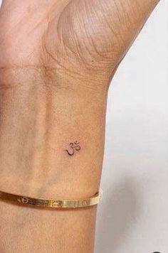 a woman's wrist with a small tattoo on the left side of her arm