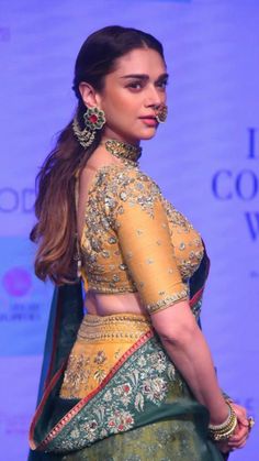 a woman in a green and yellow lehenga