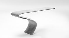 a curved metal object sitting on top of a white surface