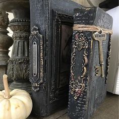 an old book with a key is sitting on a table next to some pumpkins