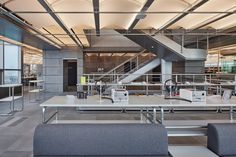 the interior of an office building with multiple tables and couches in front of them