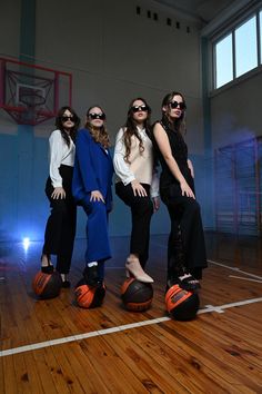 three women standing on top of a basketball ball