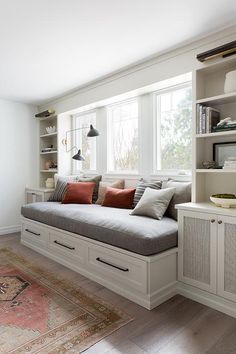 a living room filled with lots of furniture and bookshelves next to a window