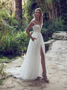 a woman in a wedding dress standing on the beach