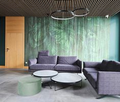 a living room filled with furniture next to a green wall