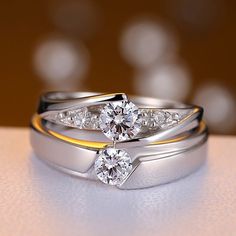 two wedding rings on top of each other with diamonds in the middle and gold bands around them