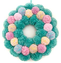 a colorful wreath with pom - poms hanging from it