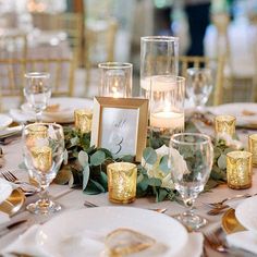 the table is set with candles, plates and place settings for an elegant wedding reception