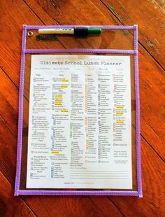 the ultimate school lunch planner is displayed on a wooden table with a marker and pen