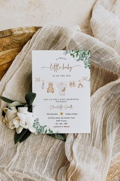 a baby shower is shown with flowers and greenery on the bottom of the card