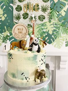 there is a cake with animals on it and a wild one sign above the cake