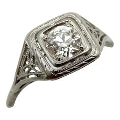 an antique style diamond ring with filigrees