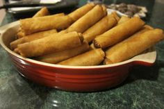 a red bowl filled with fried food on top of a counter