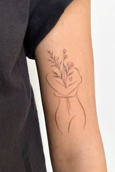 a person with a tattoo on their arm holding a flower in it's hand