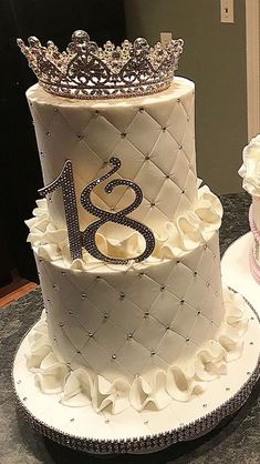 two tiered cakes with white frosting and silver decorations