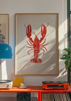 a red lobster print hangs on the wall next to a blue lamp and record player