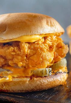 a fried chicken sandwich with cheese and pickles