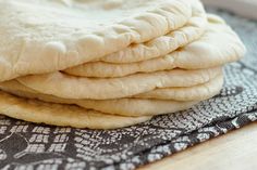 a stack of uncooked pita bread sitting on top of a blue and white towel