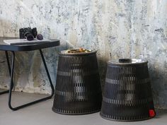 two black baskets sitting next to each other in front of a wall with a camera on it