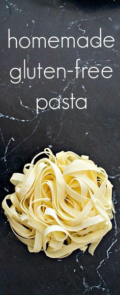 a pile of uncooked pasta sitting on top of a black counter next to a sign that says homemade gluten - free pasta