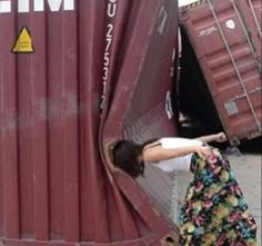 a woman leaning against the side of a train car with her hand on it's door