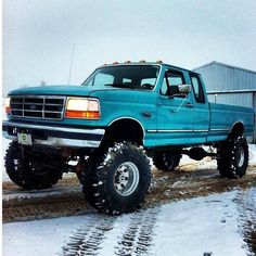 a blue pick up truck parked in the snow