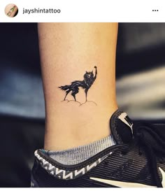 a small black bird tattoo on the ankle