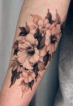 a black and white flower tattoo on the arm