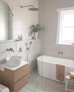 a bathroom with a bathtub, sink and toilet next to a large mirror on the wall