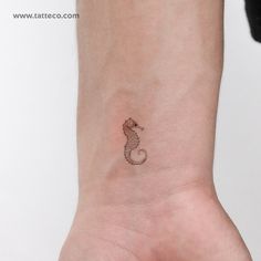 a small seahorse tattoo on the wrist