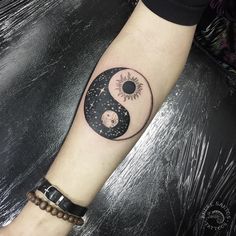 a person with a tattoo on their arm that has the sun and moon in it