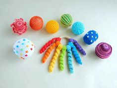 several crocheted toys are arranged on a white surface, including balls and spirals