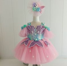 * We deliver your orders in a very short time with fast shipping (UPS or Fedex). * You do not pay extra for fast shipping. Express shipping fee is included in the dress price. * This costume, decorated with carefully crafted oysters, fish tails, pearls, and starfish, was used with five layers of dream tulle skirt and sequin fabrics on the upper body. * The inner surface of the upper body is completely lined with organic cotton fabric and does not irritate your baby's skin. * It is a great costume for birthdays, special occasions, photo shoots. * The hair bow/band/clip prepared in accordance with the dress concept is sent with the costume. * Hair band or hair bow or hair clip is our gift. (you can choose any) You do not pay extra for hair clips, hair bands or hair bows. * We recommend that Tinkerbell Costume Kids, Birthday Dress Photoshoot, Fish Tails, First Birthday Dress, Dress Photoshoot, First Birthday Dresses, Dress Tutu, Photoshoot Dress, Disney Dresses