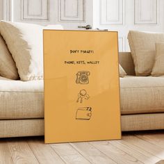 a yellow sign sitting on top of a wooden floor next to a couch