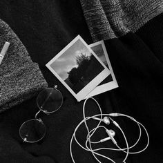 black and white photograph of headphones, sunglasses, and sweater