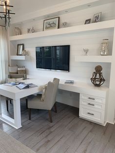 a white desk with two chairs and a television mounted on the wall