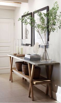 a table with two vases and some plants on it