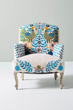 an upholstered chair with blue and orange designs on it's back, against a white background