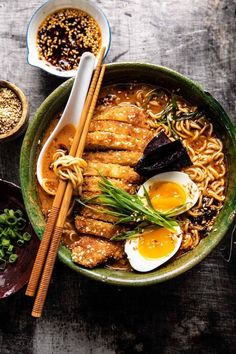 a bowl of ramen with chopsticks and an egg