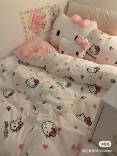 two hello kitty pillows are on top of a bed with white sheets and pink pillow cases